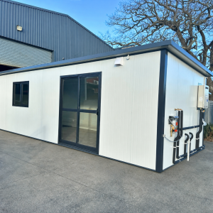 Front and side view of an 8.08m x 2.6m portable cabin with an entrance door and black-framed windows